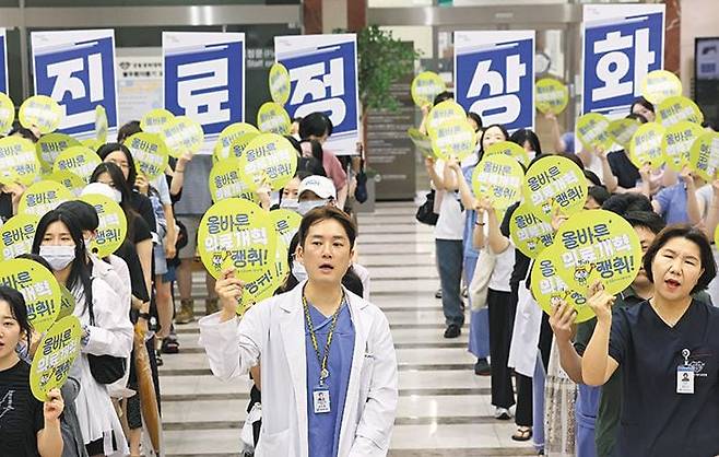 “이젠 환자 곁으로 돌아오세요” - 의정 갈등이 이어지는 가운데 18일 서울 강동구 강동경희대병원에서 병원 소속 보건의료노조 조합원들이 진료 정상화를 촉구하는 손팻말을 든 채 구호를 외치고 있다. /연합뉴스