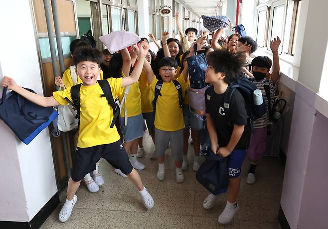 학생들이 여름 방학식을 마친 뒤 교실에서 나와 복도에서 환호하고 있다. 김영원 기자