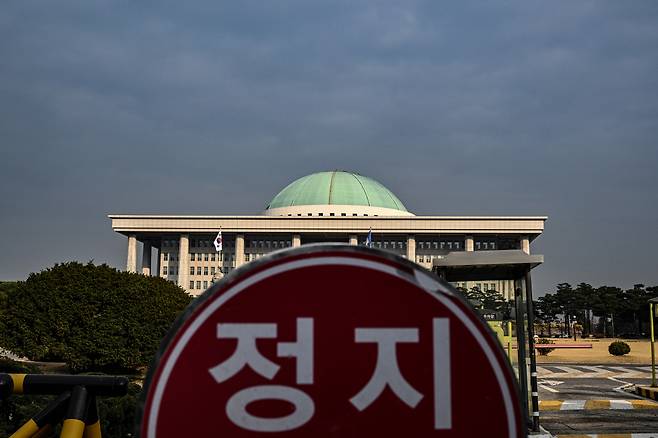 서울 영등포구 여의도의 먹구름 낀 국회의사당 앞으로 정지 안내판이 보이고 있다. 임세준 기자