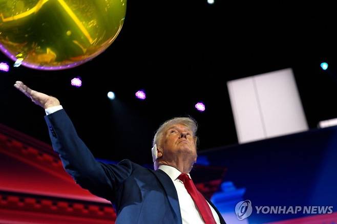 Former US President and 2024 Republican presidential candidate Donald Trump pushes a balloon after accepting his party's nomination at the end of the last day of the 2024 Republican National Convention at the Fiserv Forum in Milwaukee, Wisconsin, on July 18, 2024. Days after he survived an assassination attempt Trump won formal nomination as the Republican presidential candidate and picked Ohio US Senator J.D. Vance for running mate. (Photo by Nick Oxford / AFP)