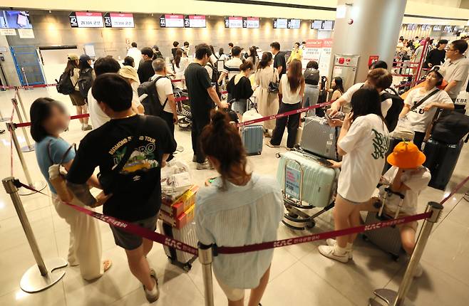 Passengers crowd in front of the ticketing counter of Eastar Jet at Jeju International Airport following the massive disruption to Microsoft systems, Friday. (Yonhap)