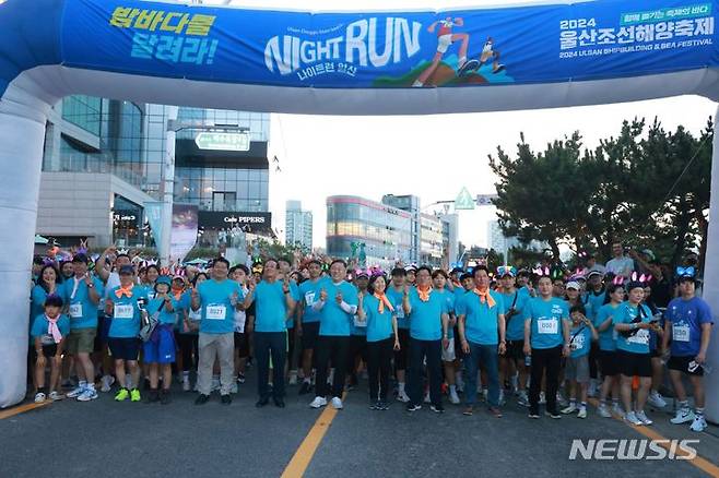 [울산=뉴시스] 박수지 기자 = 2024 울산조선해양축제가 19~21일 일산해수욕장에서 개최된 가운데 나이트런 일산 참가자들이 기념촬영을 하고 있다. (사진=동구 제공) 2024.07.21. photo@newsis.com