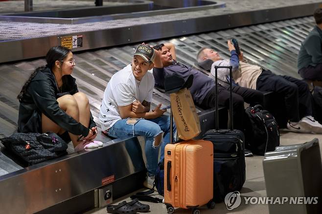 20일(현지시간) 미국 미시간 공항에서 수하물이 나오길 기다리는 승객들 [AFP=연합뉴스. 재판매 및 DB 금지]