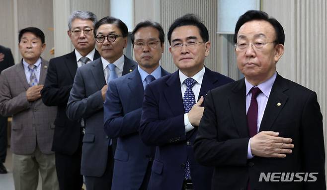 [서울=뉴시스] 이영환 기자 = 김관용(오른쪽부터) 민주평화통일자문회의(민주평통) 수석부의장과 태영호 신임 사무처장 등이  22일 오전 서울 중구 민주평통 사무처 대회의실에서 열린 27대 사무처장 취임식에서 국민의례를 하고 있다. 2024.07.22. 20hwan@newsis.com