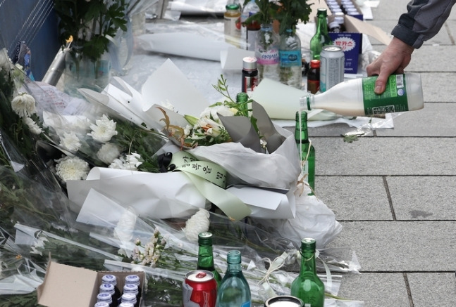 지난 4일 오전 서울 중구 시청역 인근 역주행 사고 현장에서 한 추모객이 술을 따르고 있다. 해당 교차로에서는 이달 1일 운전자 차모(68)씨가 몰던 승용차가 역주행하며 인도로 돌진해 9명이 사망했다. 연합뉴스