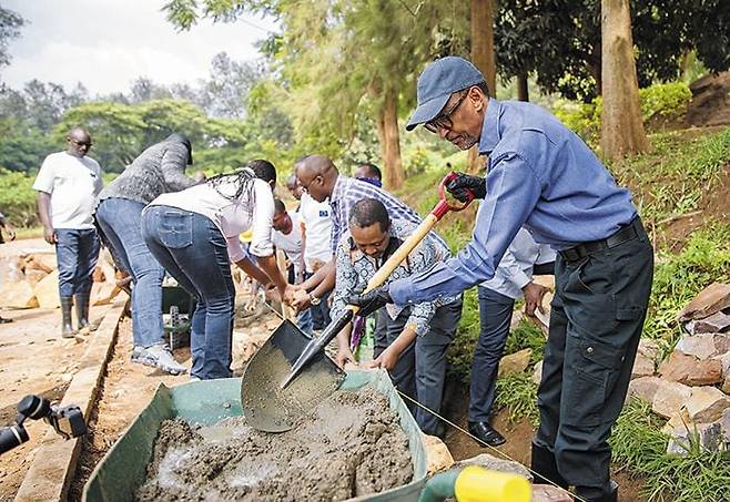 폴 카가메 르완다 대통령이 2019년 11월 수도 키갈리에서 우무간다 활동의 일환으로 주민들과 도로 주변을 정비하고 있다. 카가메 대통령은 제노사이드 이후 사회와 국가의 통합을 위해 다양한 프로그램을 도입했다. 르완다인들은 우무간다를 통해 마을의 기반 시설을 정비하는 동시에 이웃 간 친목도 다지고 있다. /르완다 대통령실