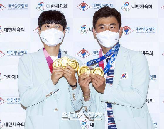 양궁 국가대표 선수단이 2020 도쿄올림픽을 마치고 1일 오후 인천국제공항을 통해 귀국했다. 각각 3관왕과 2관왕을 차지한 양궁대표팀 안산(왼쪽)과 김제덕이 입국장에 도착해 메달을 들고 포즈를 취하고 있다. 인천공항=김민규 기자