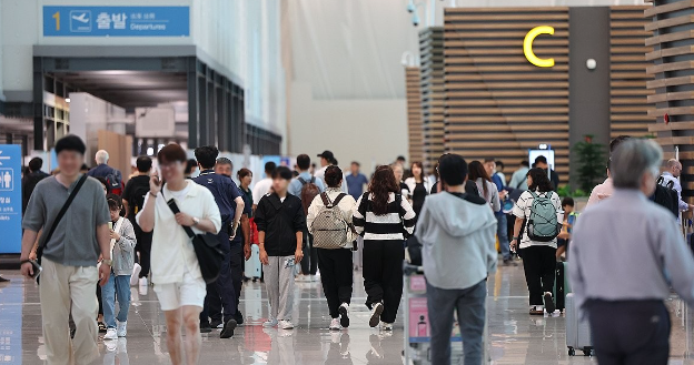 17일 인천국제공항 제2여객터미널 출국장에서 휴가철을 맞은 여행객들이 탑승 수속을 위해 이동하고 있다. 연합뉴스