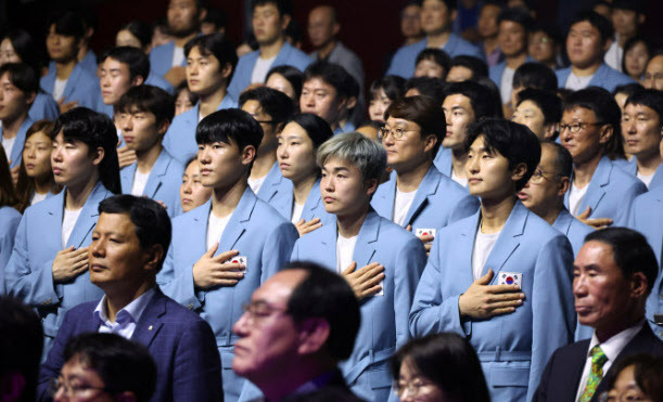 9일 오후 서울 송파구 올림픽공원 올림픽홀에서 열린 2024 파리하계올림픽대회 결단식에서 국가대표 선수와 참석자들이 국기에 경례하고 있다. [연합뉴스]