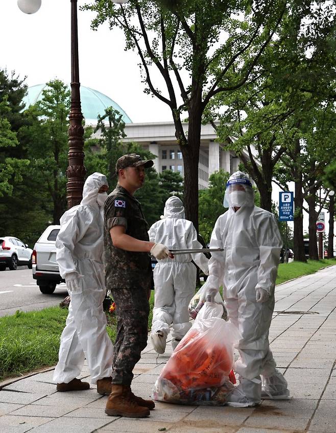 북한이 24일 오전부터 열번째 쓰레기 풍선을 경기 북부 등 남쪽으로 무차별 살포하면서 남북 간 안보 위기감이 재차 고조되고 있다. 이날 서울 여의도 국회도서관 앞에 떨어진 쓰레기 풍선 내용물을 관계자들이 확인하고 있다(위 사진). 아래 사진은 용산 대통령실 경내에 북한이 날려보낸 쓰레기 풍선이 낙하하는 모습 연합뉴스 뉴스1