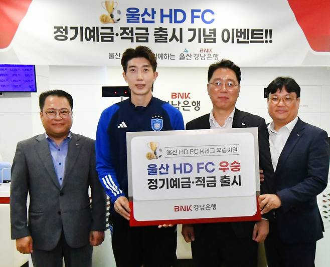 BNK경남은행 김형태 부장(사진 오른쪽 두번째)과 울산 HD FC 조현우 선수(사진 왼쪽 두번째) 등이 ‘울산 HD FC 우승 예ㆍ적금 출시 증서'를 들고 기념촬영을 하고 있다./사진=경남은행