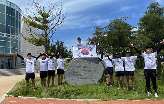 울릉군 안용복기념관 앞 김민기 씨 ‘내 나라 내 겨레’ 노래비 앞에서 태극기를 들고 기념촬영하고 있는 학생들.