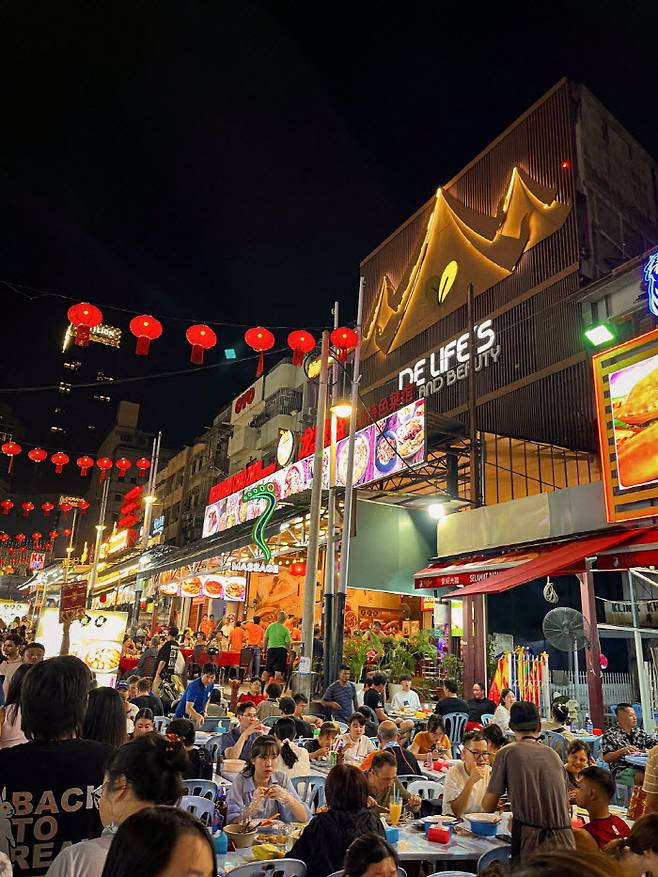 일렬로 나열된 화려한 식당들이 잘란 알로의 밤을 빛내고 사람들은 언제나 북적인다