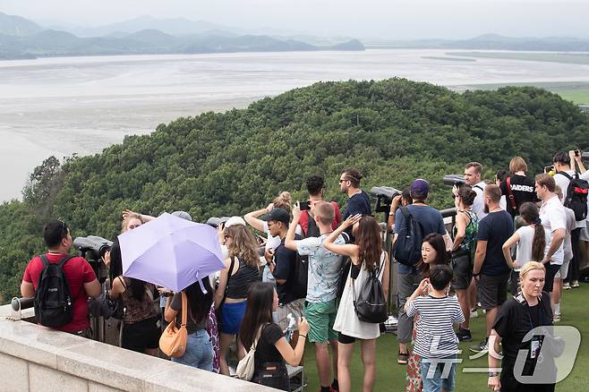 북한이 9번째 대남 오물풍선을 살포한 21일 경기 파주시 오두산통일전망대를 찾은 관광객들이 망원경으로 북녘땅을 바라보고 있다. 우리 군은 서부·중부·동부전선에 배치된 고정식 확성기를 릴레이식으로 돌아가며 제한적으로 방송하며 대응해오다 이번에 전방 지역 모든 확성기를 동시에 가동하는 방식으로 전환했다. 2024.7.21/뉴스1 ⓒ News1 유승관 기자