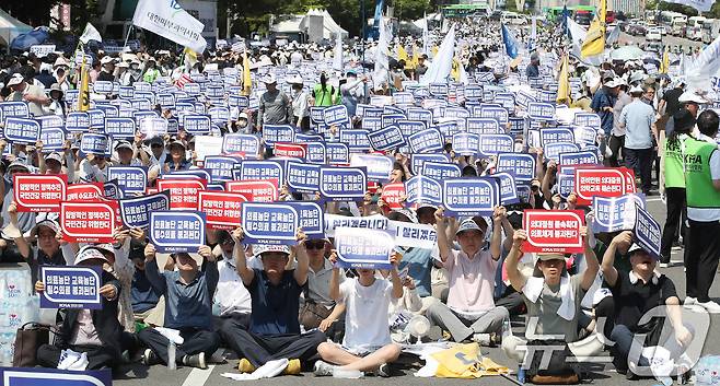 18일 서울 영등포구 여의도 환승센터 주변에서 열린 대한의사협회 전국 의사 총궐기대회에서 참석자들이 손팻말을 들고 정부에 '의대 증원' 철회를 촉구하고 있다. 2024.6.18/뉴스1 ⓒ News1 임세영 기자