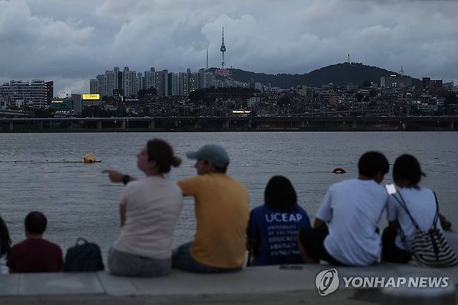 서울 전역에 폭염주의보가 내리며 더운 날씨를 보인 24일 저녁 시민들이 서울 서초구 반포한강공원에서 휴식하고 있다.ⓒ연합뉴스