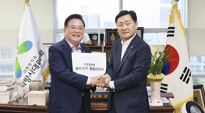 24일 세종시에 있는 대통령 직속 지방시대위원회를 찾은 김관영 전북도지사(오른쪽)가 우동기 지방시대위원회 위원장에게 ‘완주·전주 통합건의서’를 전달하고 있다. 전북도 제공