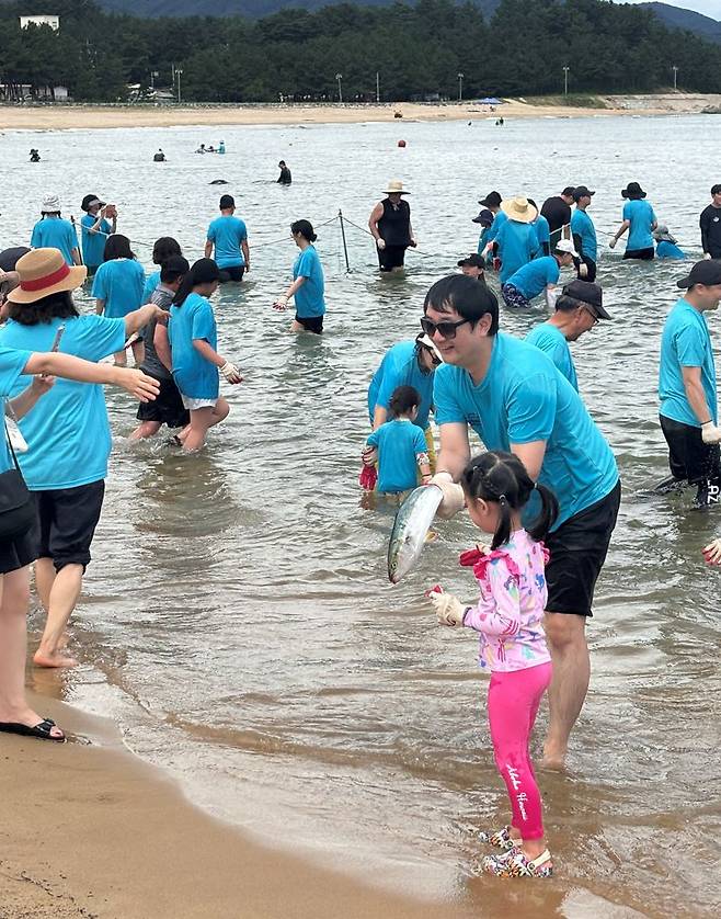 지난 23일 강원도 양양군 남애 해수욕장 일대에서 개막한 ‘2024년 수협은행 사랑海 썸머페스티벌’ 참가 고객 가족이 맨손 물고기 잡기를 체험하며 즐거워하고 있다. 사진=Sh수협은행 제공