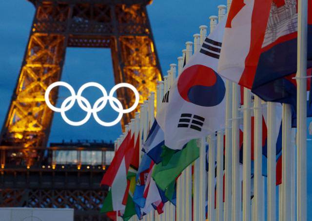 2024 파리올림픽 개막을 이틀 앞둔 24일 프랑스 파리 샤요궁의 태극기와 각국 국기 뒤로 에펠탑의 조명이 빛나고 있다. 연합뉴스