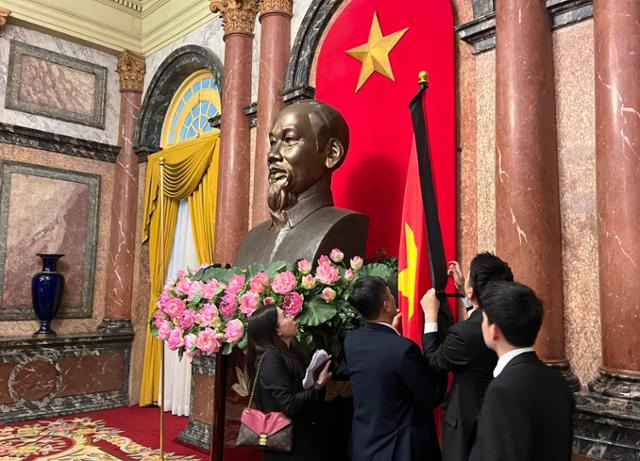 25일 한덕수 국무총리와 또럼 베트남 국가주석 간 양자 회담이 열린 하노이 주석궁에서 관계자들이 베트남 국기인 금성홍기에 검은색 띠를 두르고 있다. 하노이=허경주 특파원