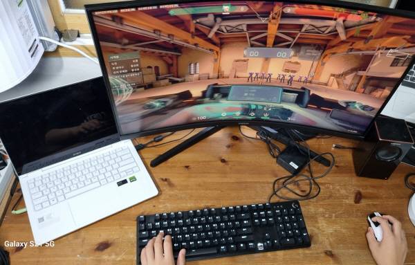 HP 오멘 14 슬림(왼쪽)과 게이밍 모니터, 키보드, 마우스(무선 상태), 스피커를 연결해 발로란트 게임을 하는 모습. 정옥재 기자