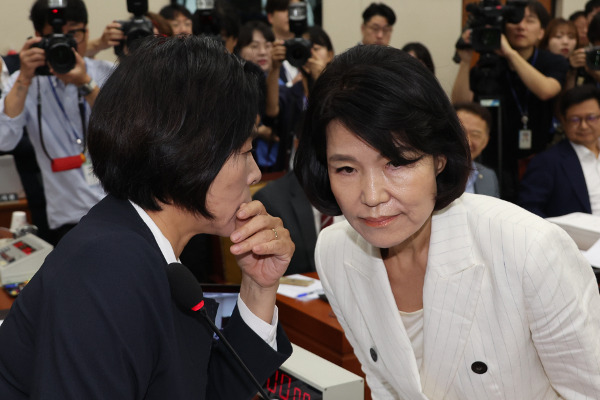 국회 과학기술정보방송통신위원회 위원장인 최민희(왼쪽) 더불어민주당 의원이 24일 열린 이진숙 방송통신위원장 후보자 인사청문회에서 선서문을 전달한 뒤 인사하지 않고 자리로 돌아가는 이 후보자를 불러 세워 귀에 대고 이야기하고 있다. 최 위원장은 “저와 싸우려 하시면 안 된다”고 말했다.   연합뉴스