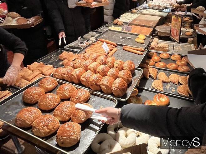 대기업 프랜차이즈 빵집 출점 규제 등 제한으로 개인 빵집과 카페·편의점 등에서의 빵 사업이 점점 커지고 있다. 지난해 12월 대전 중구 성심당 본점에서 고객들이 빵을 고르고 있다. /사진=김서현 기자