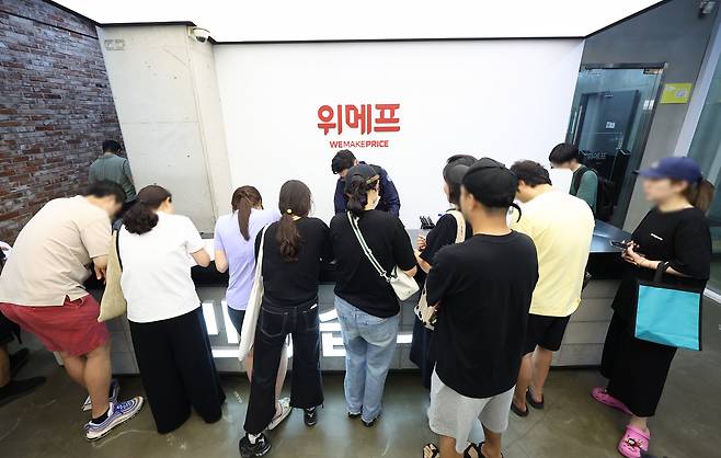 25일 새벽 서울 강남구 위메프 본사에서 정산 지연 사태와 관련 상고객들이 환불 요청서를 작성하고 있다. [연합]