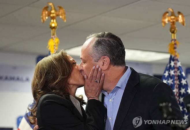 남편과 키스하는 해리스 미 부통령 (윌밍턴 AFP=연합뉴스) 카멀라 해리스 미국 부통령이 22일(현지시간) 델라웨어주 윌밍턴 선거대책본부에서 발언에 앞서 남편 더그 엠호프와 키스하고 있다. 해리스 부통령은 이날 낸시 펠로시 하원의원(캘리포니아) 등 민주당 핵심 인사들의 지지를 받으면서 민주당 대선 후보직 확정 가능성이 커졌다. 2024.07.23 passion@yna.co.kr