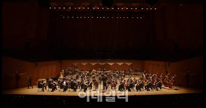 지난 21일 서울 서초구 예술의전당 콘서트홀에서 열린 국립심포니오케스트라 제250회 정기연주회 ‘드보르자크, 교향곡 7번’의 한 장면. 이정일 악장의 줄이 끊어진 바이올린을 전달 받은 이은정 단원이 줄을 교체하기 위해 무되 왼편 출입구로 향하고 있다.  (사진=국립심포니오케스트라)