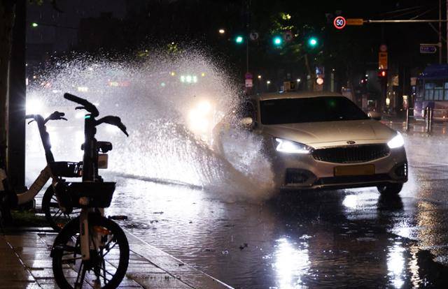 폭우가 내린 22일 밤 서울 시내에서 차량이 물보라를 만들며 지나가고 있다. 연합뉴스
