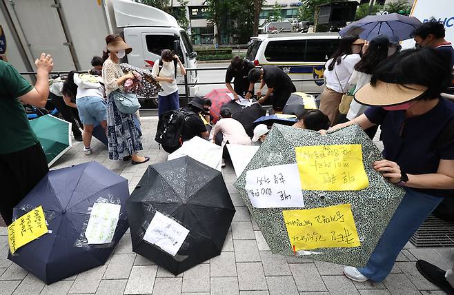 28일 오후 티몬·위메프의 모회사인 서울 강남구 큐텐 앞에서 피해자들이 회사 측에 빠른 환불과 대책 마련 등을 촉구하며 우산 시위를 하고 있다. [사진 = 연합뉴스]