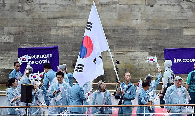 2024 파리 올림픽 개회식이 열린 26일(현지시간) 프랑스 파리 센강에서 대한민국 선수단의 기수 우상혁(오른쪽)과 김서영이 보트를 타고 트로카데로 광장을 향해 수상 행진을 하고 있다. 연합뉴스