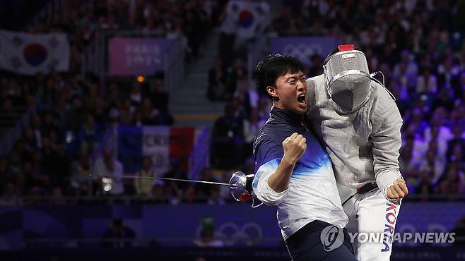 펜싱 사브르 우승 차지한 오상욱 (파리=연합뉴스) 신준희 기자 = 27일(현지시간) 프랑스 파리 그랑 팔레에서 열린 2024 파리올림픽 펜싱 남자 사브르 결승전에서 파레스 페르자니(튀니지)를 꺾고 우승을 차지한 오상욱이 원우영 코치와 함께 기뻐하고 있다. 2024.7.28 hama@yna.co.kr