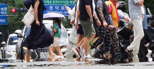 폭염 경보가 발효된 29일 대구 중구 공평네거리에서 시민들이 지열로 인한 아지랑이가 피어오르는 도로를 지나가고 있다./ 연합뉴스