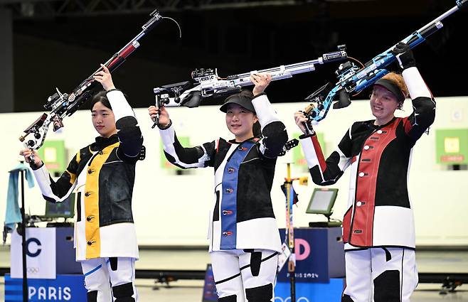 반효진(가운데)이 29일(현지시각) 프랑스 샤토루 CNTS 사격장에서 열린 2024 파리올림픽 사격 여자 10m 공기소총 결승 경기에서 금메달을 획득한 뒤 소총을 들고 기뻐하고 있다. 샤토루/올림픽사진공동취재단