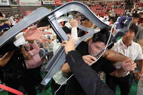 15일 오후 충남 천안시 유관순체육관에서 열린 국민의힘 제4차 전당대회 대전·세종·충북·충남 합동연설회에서 참석자들 일부가 연설중인 한동훈 후보에게 '배신자'라고 외치며 의자를 집어 던지려고 하자 경호원과 당직자들이 제지하고 있다. 뉴시스