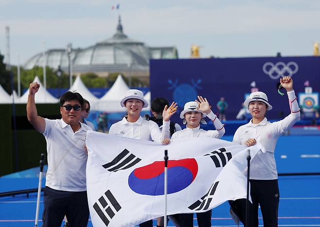 전훈영, 임시현, 남수현이 29일 프랑스 파리 레쟁발리드 양궁 경기장에서 열린 2024 파리올림픽 양궁 여자단체 결승전에서 중국을 이기고 우승을 확정한 뒤 태극기를 펼치고 있다. 연합뉴스