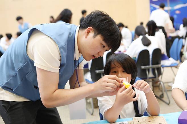 포스코퓨처엠이 경북 포항 포스코 본사에서 '2024 푸른꿈 환경캠프'를 열었다고 30일 밝혔다. 포스코퓨처엠 직원이 캠프에 참가한 어린이와 함께 전기차 모형을 만들고 있다. 포스코퓨처엠