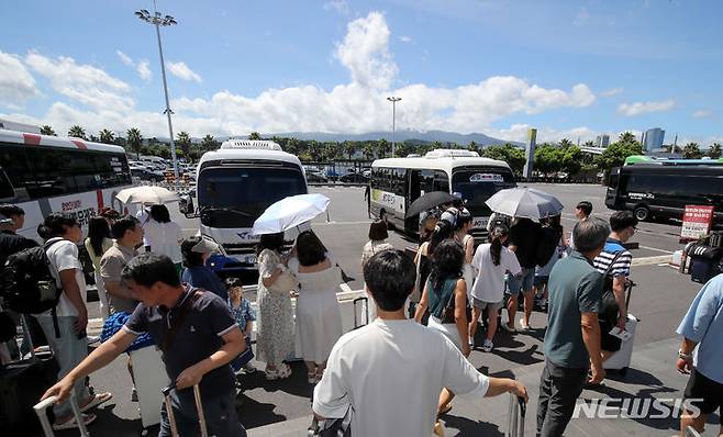 [제주=뉴시스] 우장호 기자 = 본격적인 여름 휴가철이 시작된 28일 오전 제주국제공항 내 렌터카하우스에서 관광객들이 공항과 렌터카 회사를 오가는 셔틀버스에 탑승하고 있다. 2024.07.28. woo1223@newsis.com