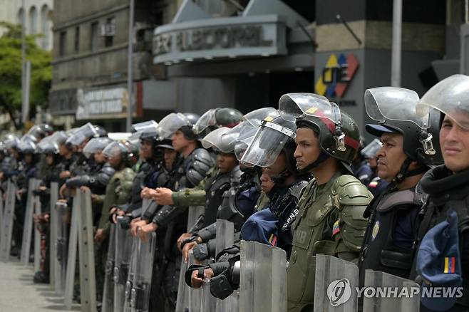 긴장 감도는 베네수엘라 선관위 (카라카스 AFP=연합뉴스) 29일(현지시간) 베네수엘라 카라카스에 있는 베네수엘라 선거관리위원회 앞에 요원들이 안전 유지를 위해 배치돼 있다. 2024.7.30