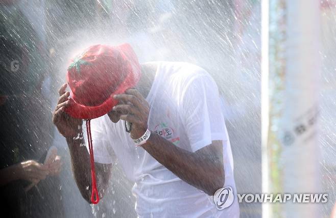 지난해 화천토마토축제에서 더위 식히는 외국인 관광객 [연합뉴스 자료사진]