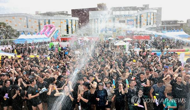 "머드의 향연에 풍덩" (보령=연합뉴스) 여름 대표 축제 보령머드축제 이틀째인 지난 20일 충남 보령 대천해수욕장을 찾은 관광객들이 시원한 머드의 향연을 한껏 즐기고 있다. [연합뉴스 자료사진]