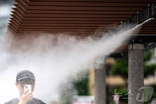 지난달 2일 일본 도쿄 긴자에서 한 남성이 쿨링포그 아래를 지나고 있다. 2024.07.02. ⓒ AFP=뉴스1 ⓒ News1 김종훈 기자