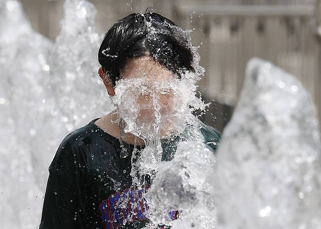 무더위가 이어진 7월 31일 서울 광화문광장 분수대에서 어린이가 더위를 식히고 있다. /연합뉴스