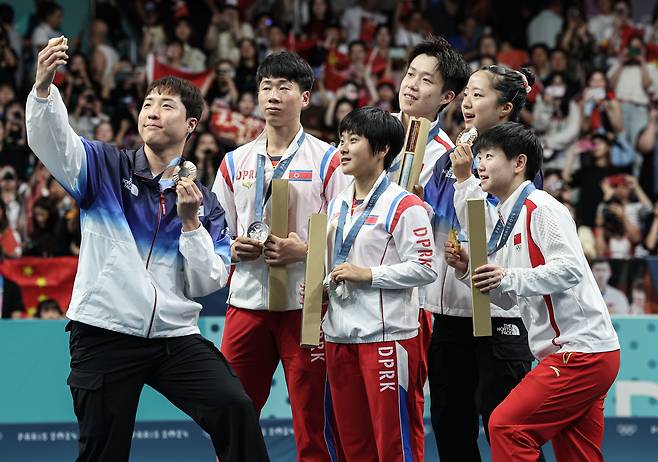 대한민국 탁구 대표팀 신유빈, 임종훈 선수가 지난달 30일(한국시각) 프랑스 파리 사우스 파리 아레나4에서 열린 '2024 파리올림픽' 탁구 혼합복식 시상식에서 금메달을 획득한 중국 왕추친, 쑨잉사와 은메달을 획득한 북한 리종식, 김금용과 함께 기념촬영을 하고 있다./뉴스1