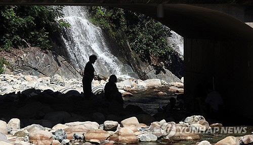 전국적으로 폭염이 이어지는 지난 7월 30일 오후 경남 김해시 대청동 장유대청계곡에서 내 그늘에서 시민들이 휴식을 취하고 있다.  [김해=연합뉴스]