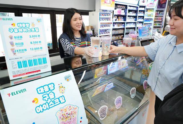 세븐일레븐 구슬 아이스크림 특화 매장에서 직원이 고객에게 대용량 구슬 아이스크림 컵을 건네주고 있다. 세븐일레븐은 구슬 아이스크림 브랜드 '디핀다트코리아'와 손잡고 편의점 6개를 특화 매장으로 만들었다. 세븐일레븐 제공