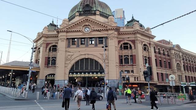 플린더스 역 앞으로 시민들이 길을 건너고 있다.