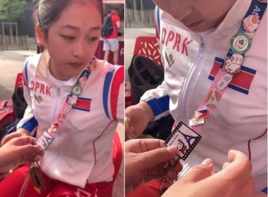 안창옥 북한 기계체조 선수가 선수촌에서 중국 자원봉사자와 배지를 교환하는 모습. 사진=샤오홍슈 캡처